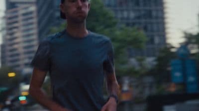 a man holding a skateboard on a city street