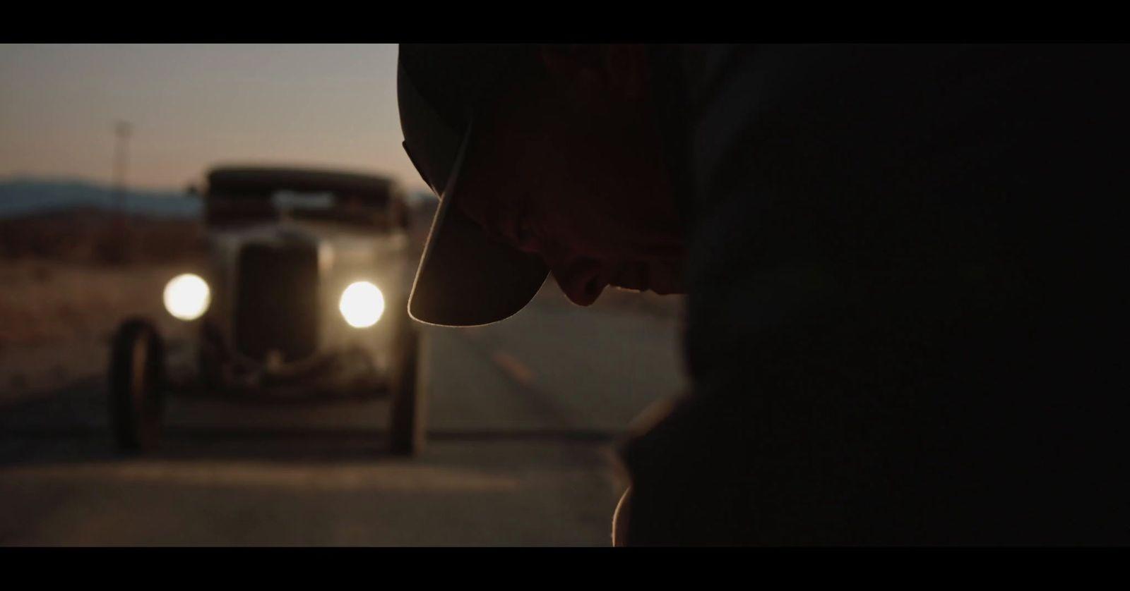 a man standing next to a truck on a road