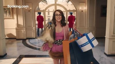 a woman in a pink dress holding shopping bags