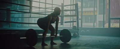 a woman standing next to a boxing ring