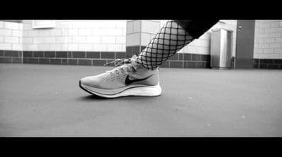 a black and white photo of a person's legs and shoes