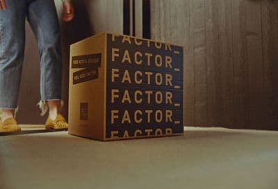 a person standing next to a box that says factor factor factor factor factor factor factor