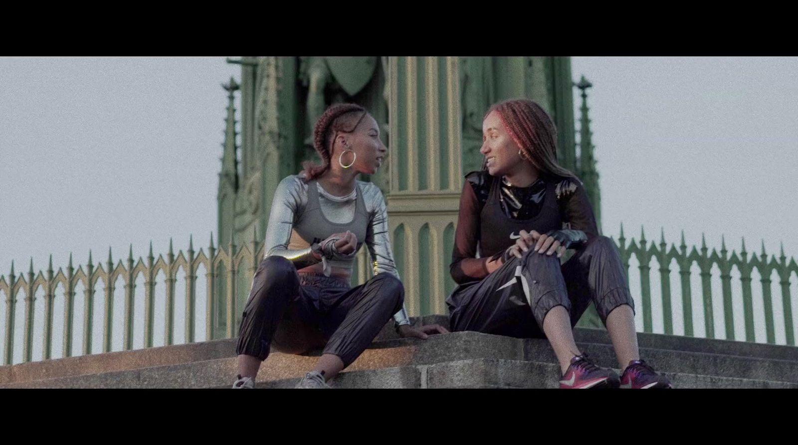 two women sitting on a ledge talking to each other