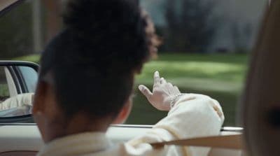 a woman sitting in a car talking on a cell phone