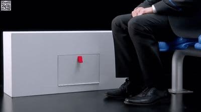 a man in a suit sitting on a chair next to a box