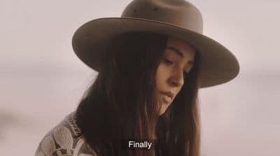 a woman with long hair wearing a hat