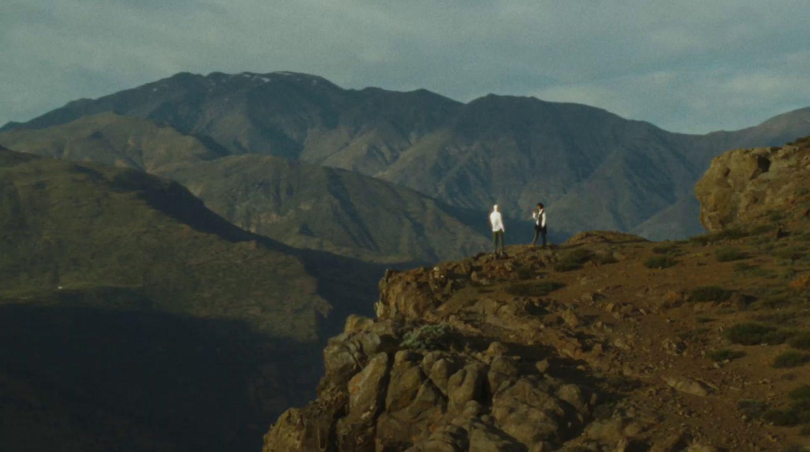 a couple of people standing on top of a mountain