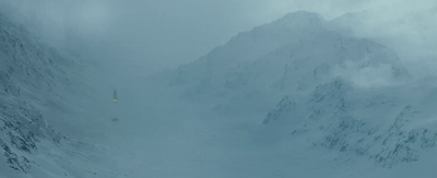 a snow covered mountain with a yellow sign in the foreground