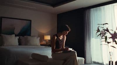 a person sitting on a bed looking at a tablet