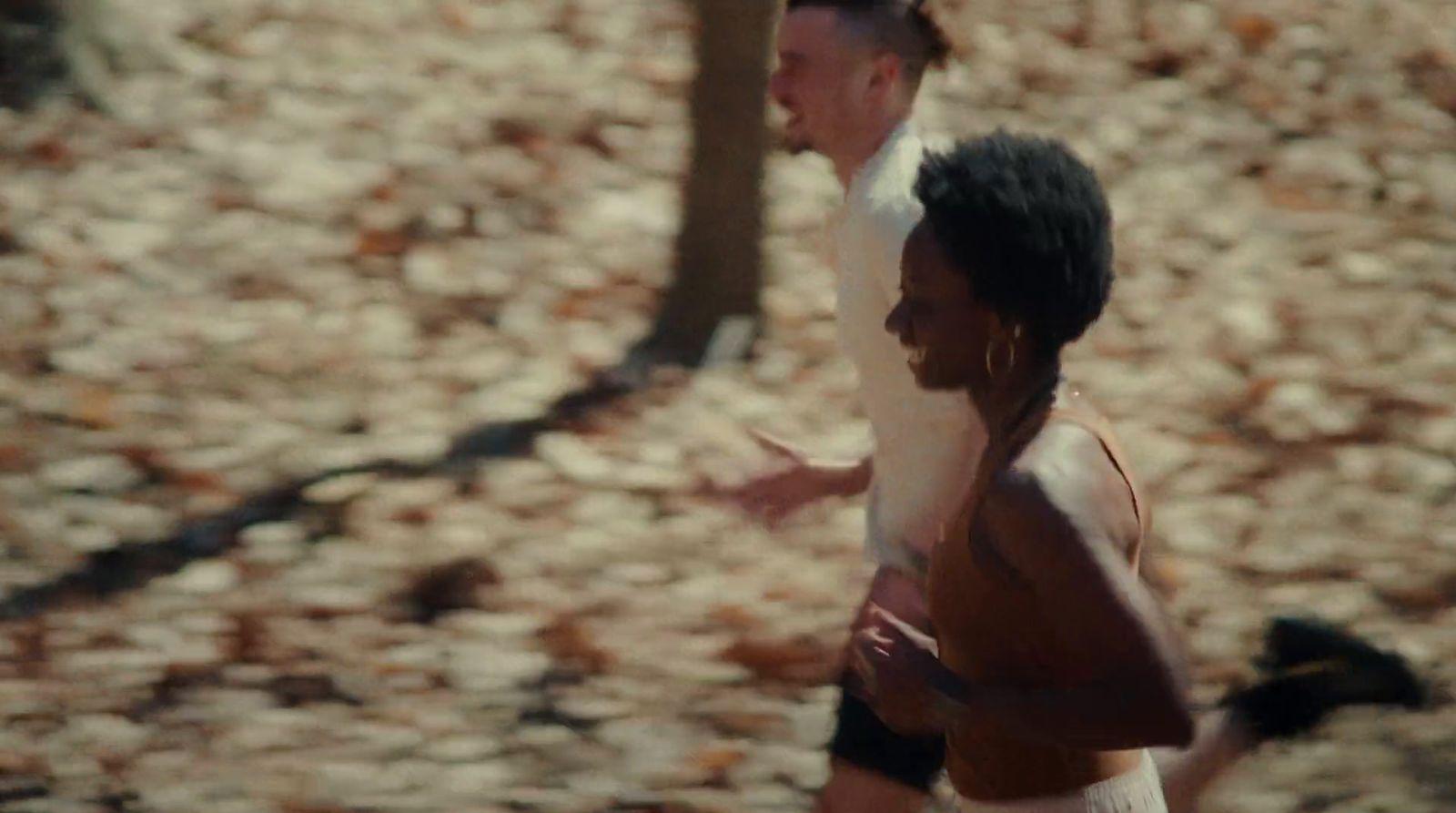 a couple of men running through a forest