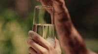 a woman holding a glass of water in her hand