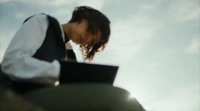 a woman with a laptop sitting on a bench