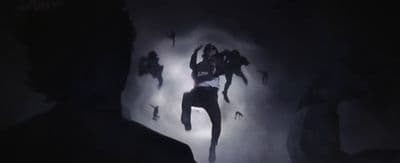 a man standing in the dark with his hands in the air