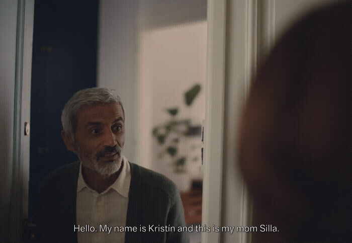 a man in a suit looking at himself in the mirror