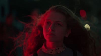 a woman with long hair standing in a dark room