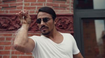 a man in a white t - shirt is holding his arm up