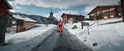 a man walking down a snow covered road