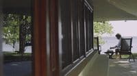 a man sitting in a chair on a porch