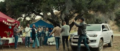 a group of people standing around a white truck
