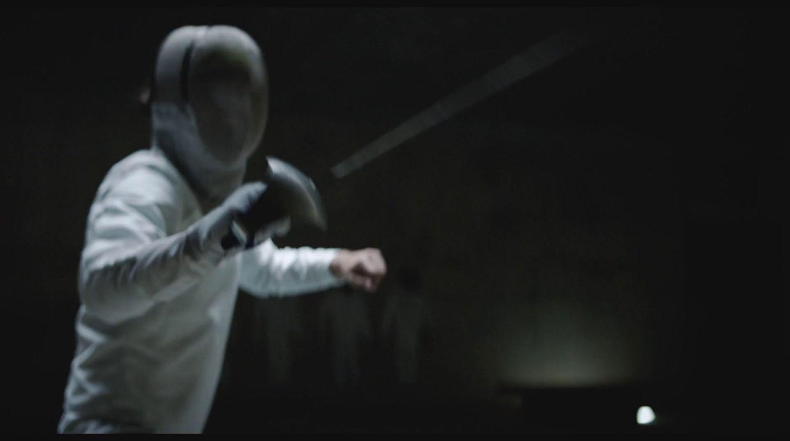 a person in a white hoodie holding a black object