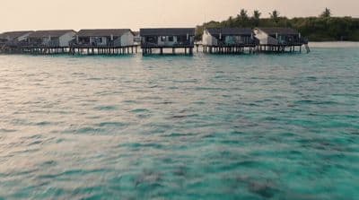 a number of houses on stilts in the water