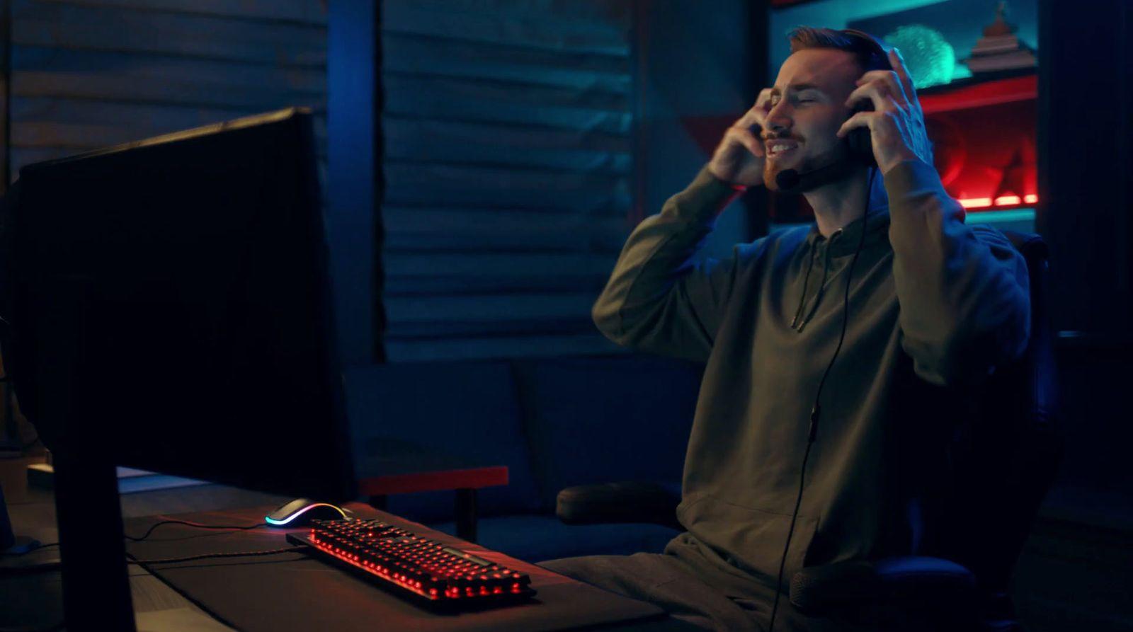 a man sitting in front of a computer talking on a cell phone