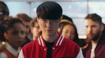 a man with glasses standing in front of a group of people
