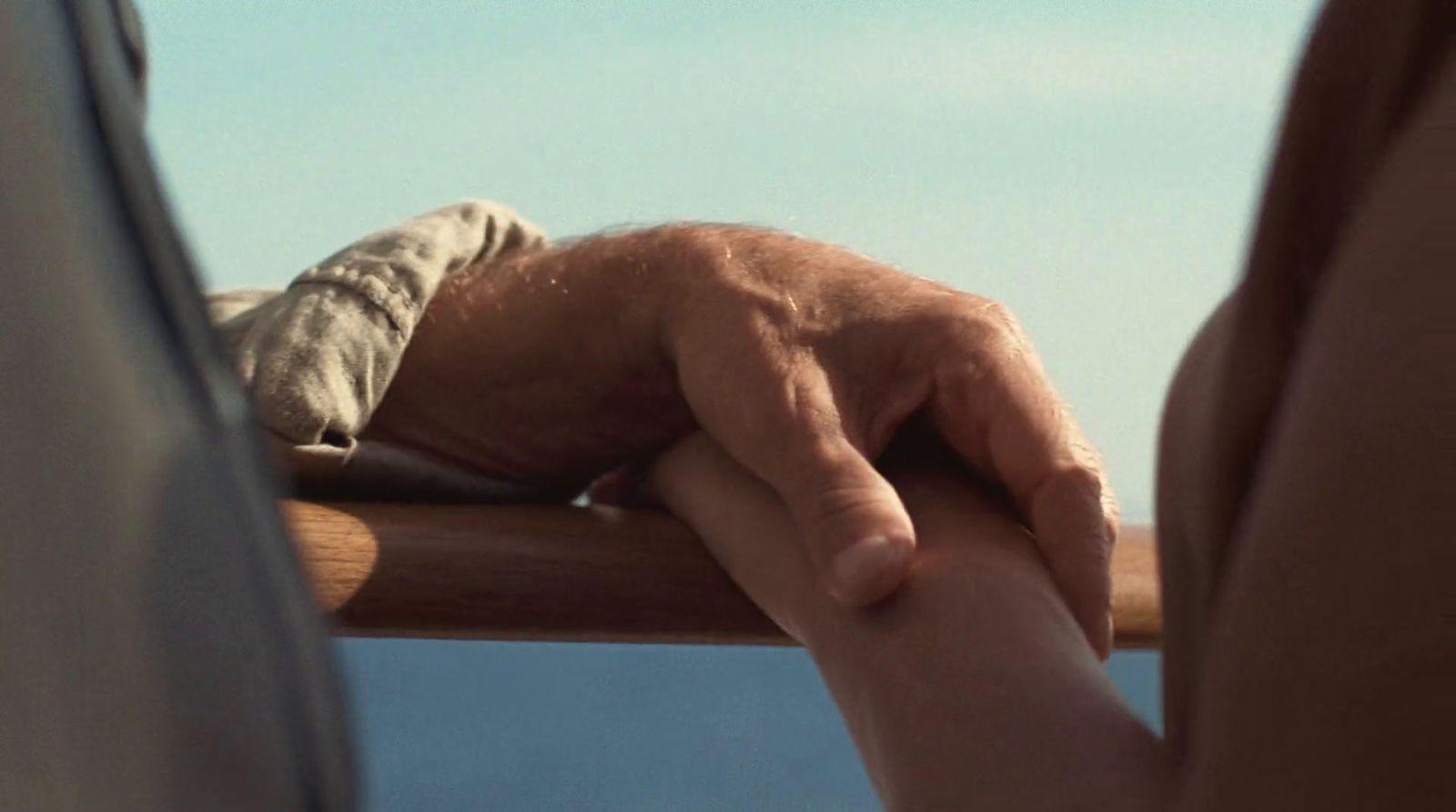 a man holding a woman's hand on top of a boat