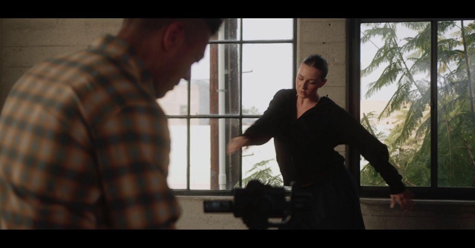 a man standing next to a woman in front of a window