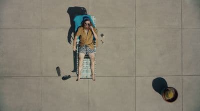 a woman laying on a chair with a backpack on her back