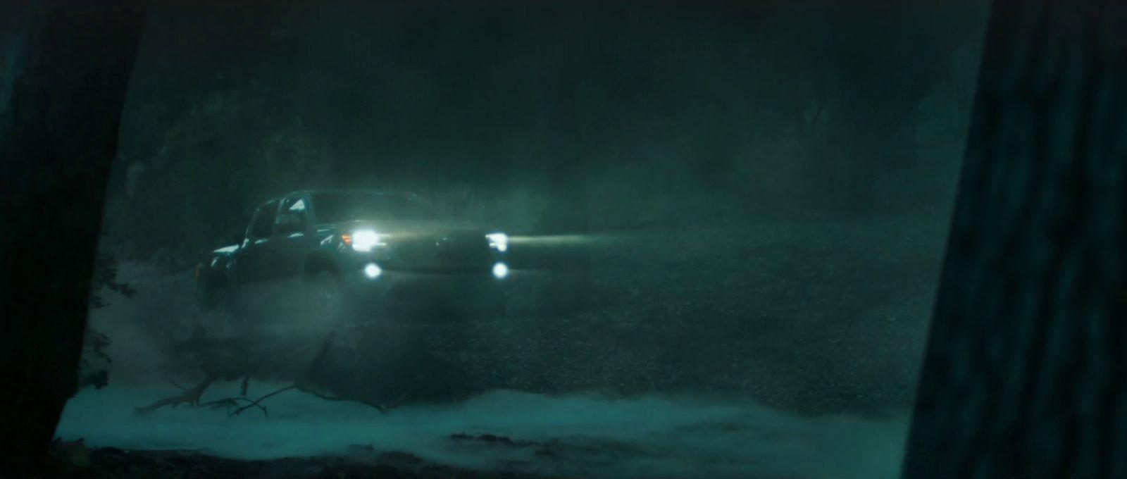 a car driving through a foggy forest at night
