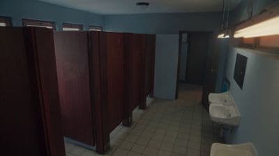 a bathroom with several stalls and a sink
