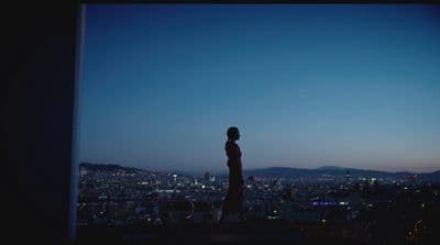 a person standing in front of a window overlooking a city