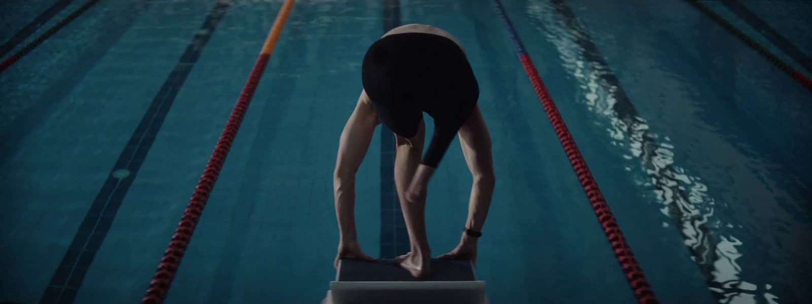 a person standing on a diving board in a pool
