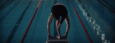 a person standing on a diving board in a pool