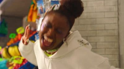 a woman in a white hoodie laughing and holding her hands up