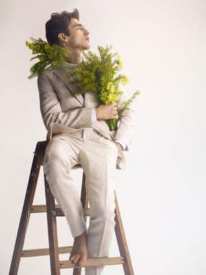 a man sitting on a ladder holding a bunch of flowers