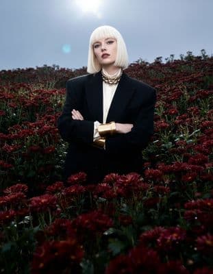 a woman standing in a field of flowers