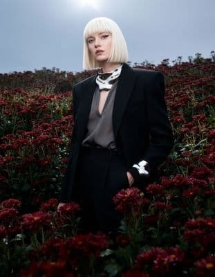 a woman standing in a field of flowers
