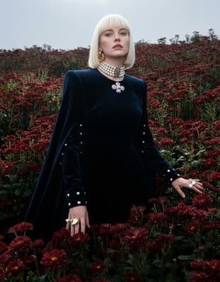 a woman standing in a field of flowers