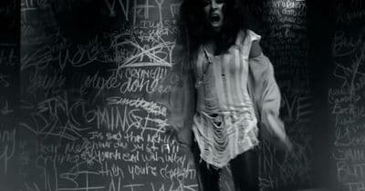 a man standing in front of a wall covered in graffiti