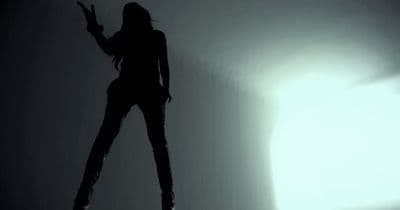 a woman standing in the shadows of a room