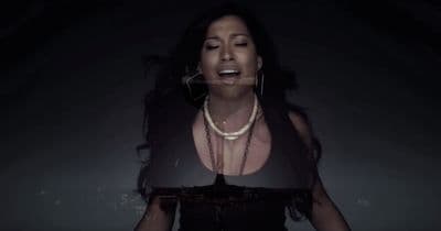a woman in a black dress with a necklace on