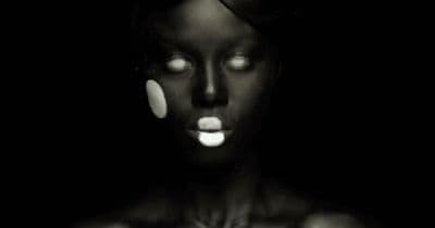 a woman with glowing eyes and black skin