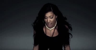 a woman in a black dress is making a face