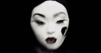 a woman with black and white makeup and white face paint