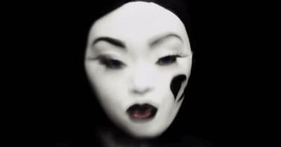 a woman with black and white makeup and white face paint