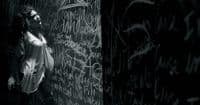 a woman standing in front of a wall covered in graffiti