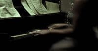 a woman sitting at a piano with sheet music on it