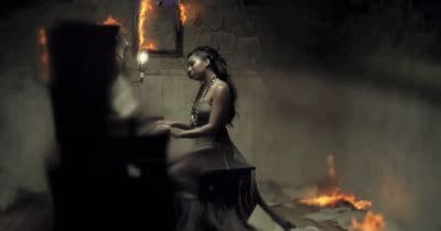 a woman sitting on a chair in a dark room